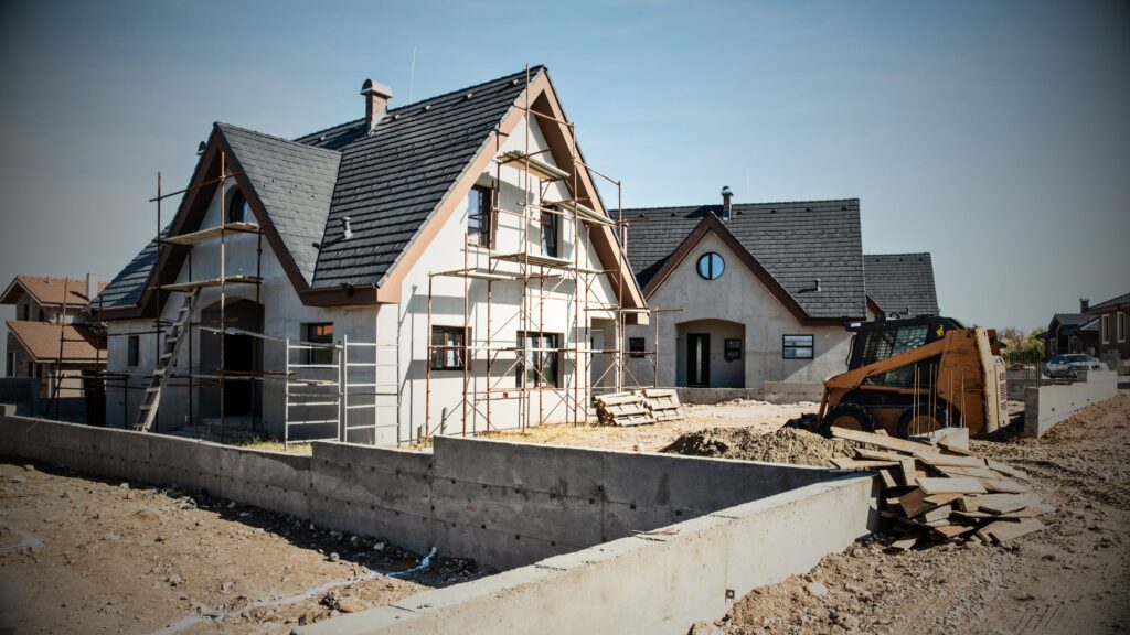 Niche Home & Contents Insurance for new builds, residential property, properties under construction as displayed by this image with scaffolding and digger, representing conveyancing for new homes and property development legal services.