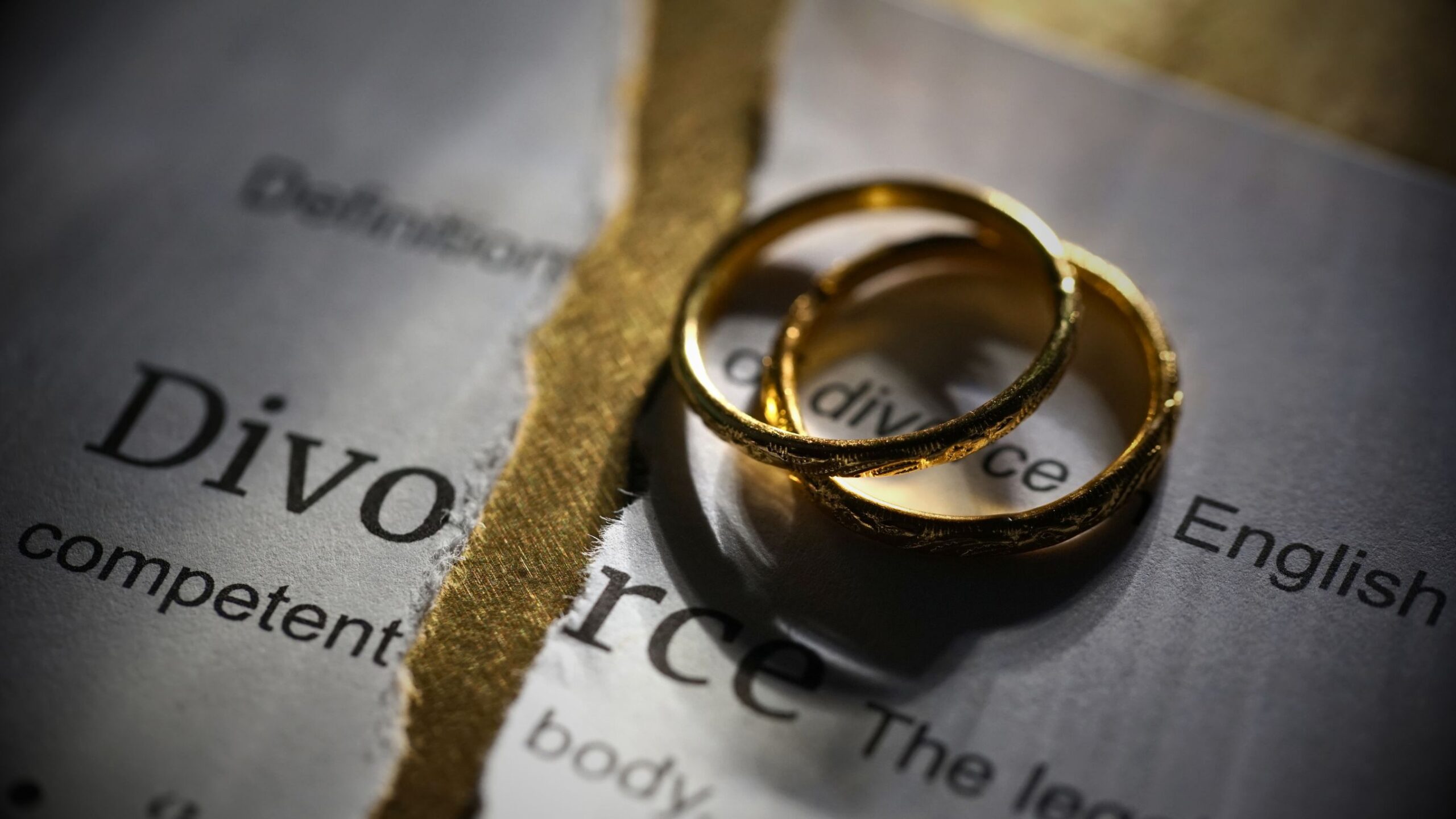 Family Matters Legal Services Two wedding rings on a torn paper with the word "Divorce," symbolising separation, legal advice, and family matters legal services.