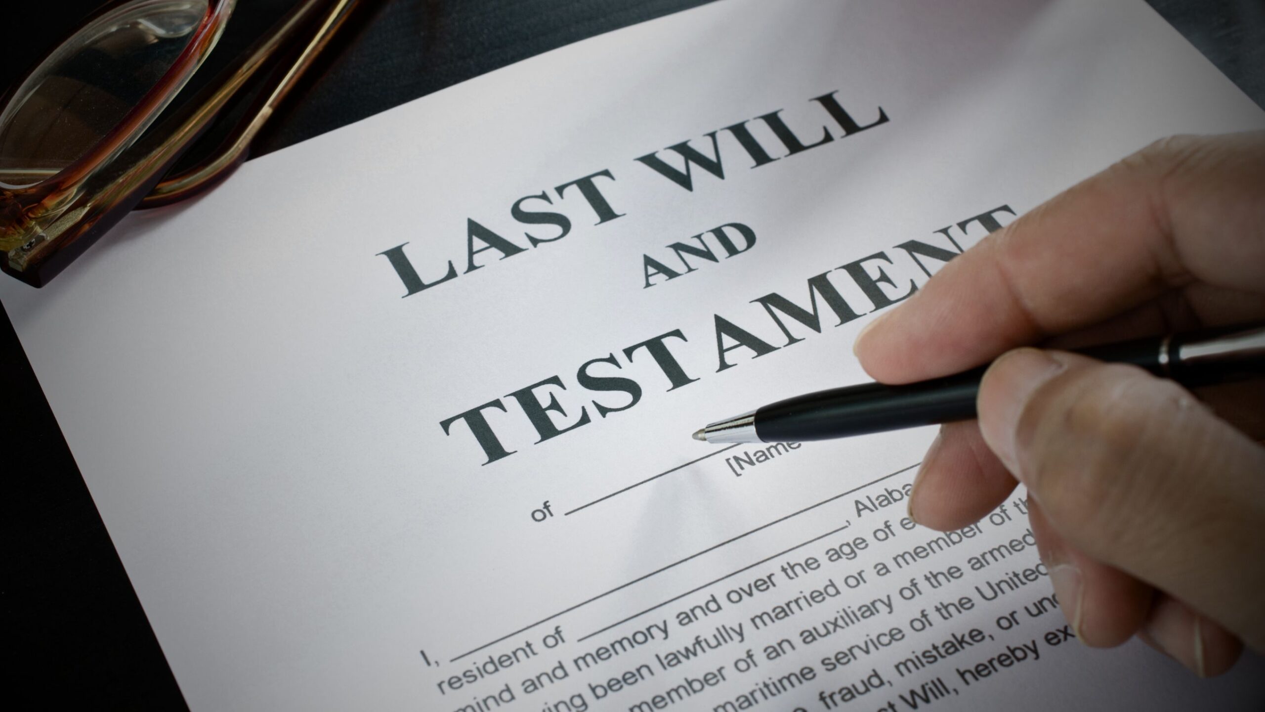 Hand pointing to Last Will and Testament document VINTTRO partner private client solicitor UK.