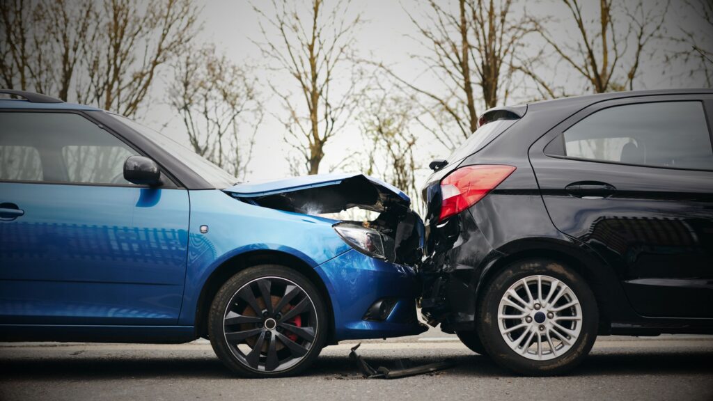 A blue car rear-ending a black car in a motor accident on a road, symbolizing a claims dispute requiring expert legal services and litigation support.