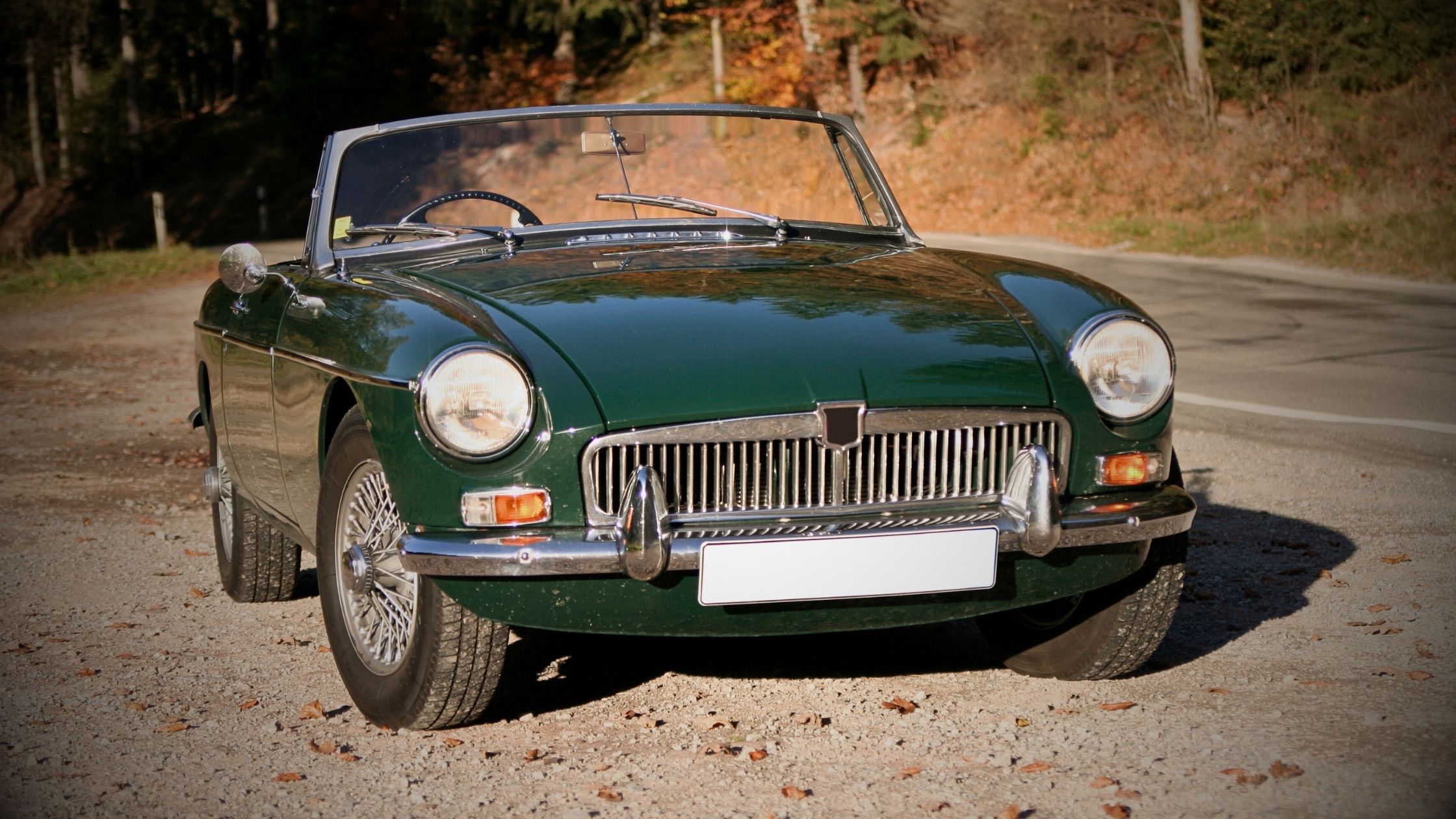 Front view of a classic British Racing Green MGB Roadster parked on a gravel area, representing a typical cherished vehicle often declared SORN during winter storage in the UK.