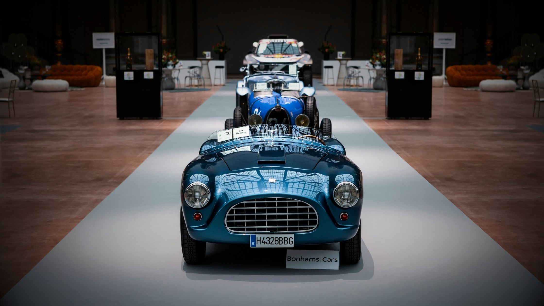 Classic blue vintage sports car displayed at a prestigious auction preview by Bonhams, highlighting rare and niche vehicle investment opportunities for global business leaders.